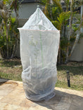 Load image into Gallery viewer, Tree Defender 6-foot plant protection system covering a young potted tree in a backyard setting.